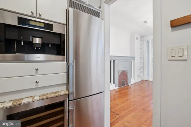 a view of kitchen with refrigerator and cabinets