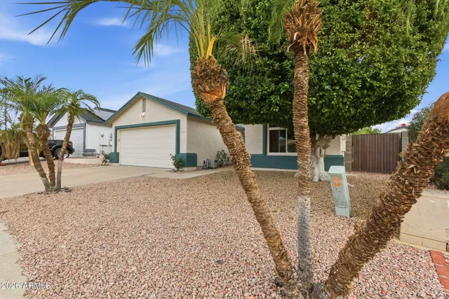 a view of a house with a yard and large tree