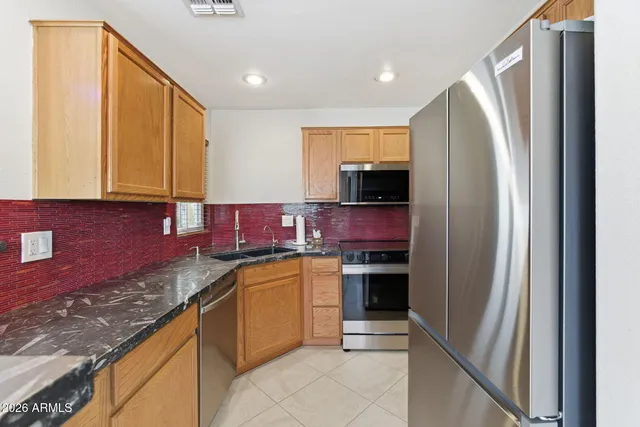 a kitchen with stainless steel appliances granite countertop a refrigerator and a sink