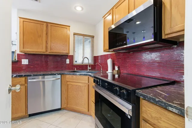 a kitchen with stainless steel appliances granite countertop a stove a sink and a microwave
