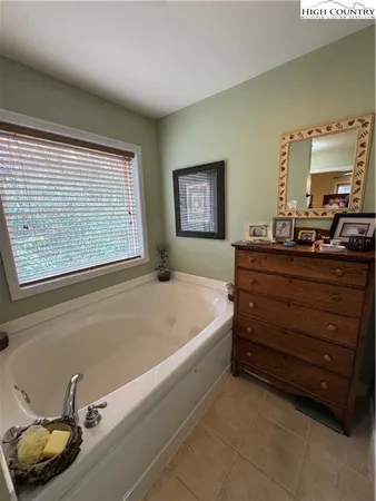 a bath room with a bed and dresser