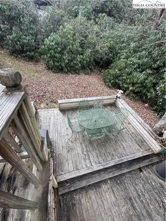 a view of a patio with lawn chairs and wooden floor