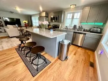 a kitchen with stainless steel appliances kitchen island granite countertop a stove and a sink