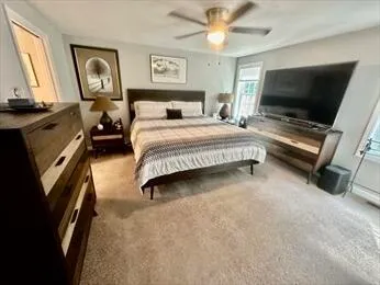 a bedroom with a bed and a flat tv screen on the dresser