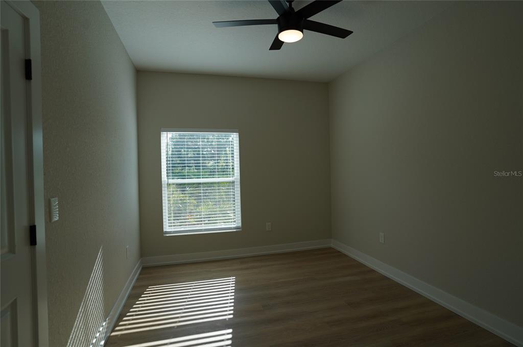 12032 Tetzel Avenue Port Charlotte, FL 33981 - Photo 12 of 32 an empty room with wooden floor closet and windows