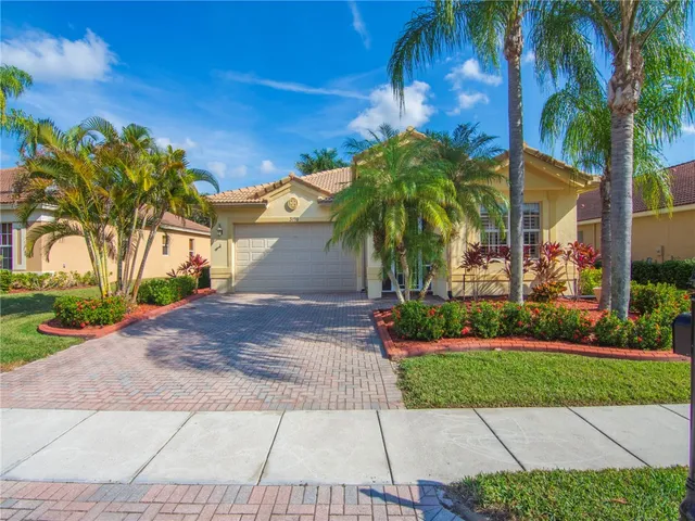 a front view of a house with a yard and potted plants