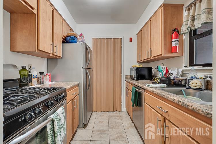 111 Beverly Hl Terrace, Unit F Woodbridge, NJ 07095 - Photo 2 of 31 a kitchen with stainless steel appliances granite countertop a stove sink and refrigerator