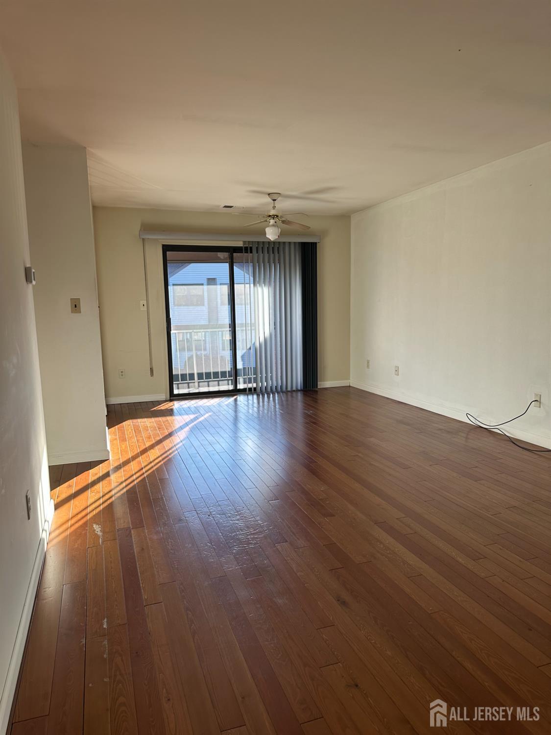 111 Beverly Hl Terrace, Unit F Woodbridge, NJ 07095 - Photo 27 of 31 a view of an empty room with wooden floor and a window