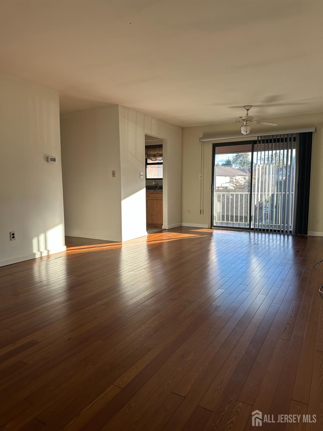 111 Beverly Hl Terrace, Unit F Woodbridge, NJ 07095 - Photo 28 of 31 a view of an empty room with wooden floor and a window