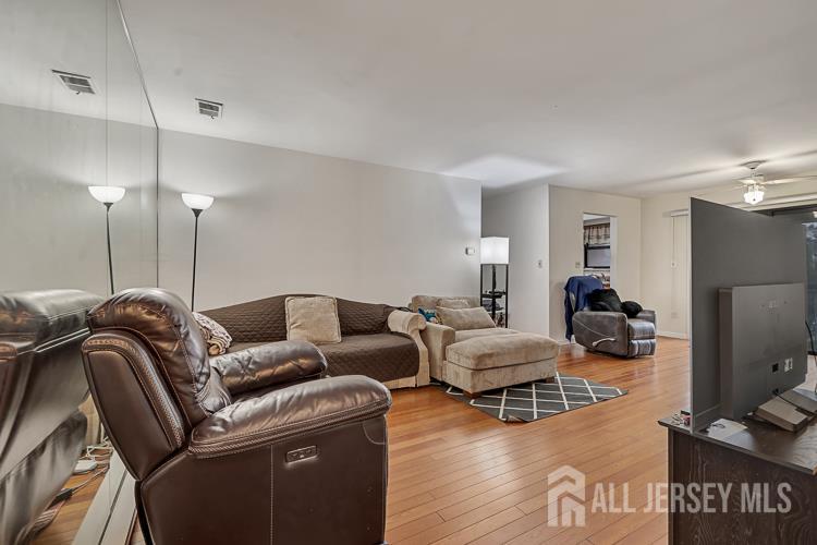 111 Beverly Hl Terrace, Unit F Woodbridge, NJ 07095 - Photo 4 of 31 a living room with furniture gym equipment and a flat screen tv
