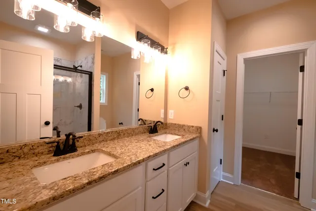a bathroom with a granite countertop shower sink and mirror