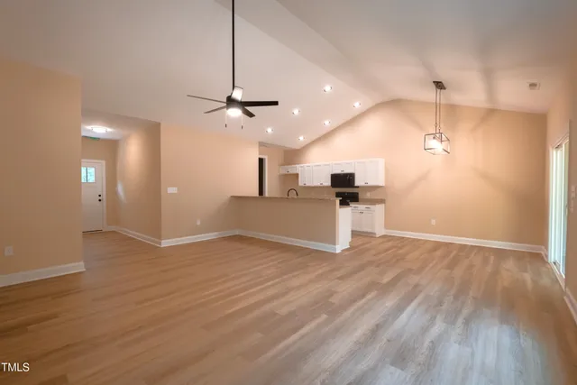 a view of empty room with wooden floor and windows