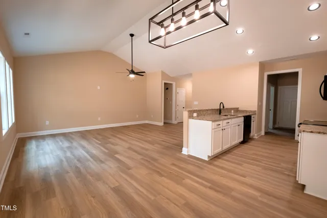 a kitchen with granite countertop a sink a counter space appliances and cabinets