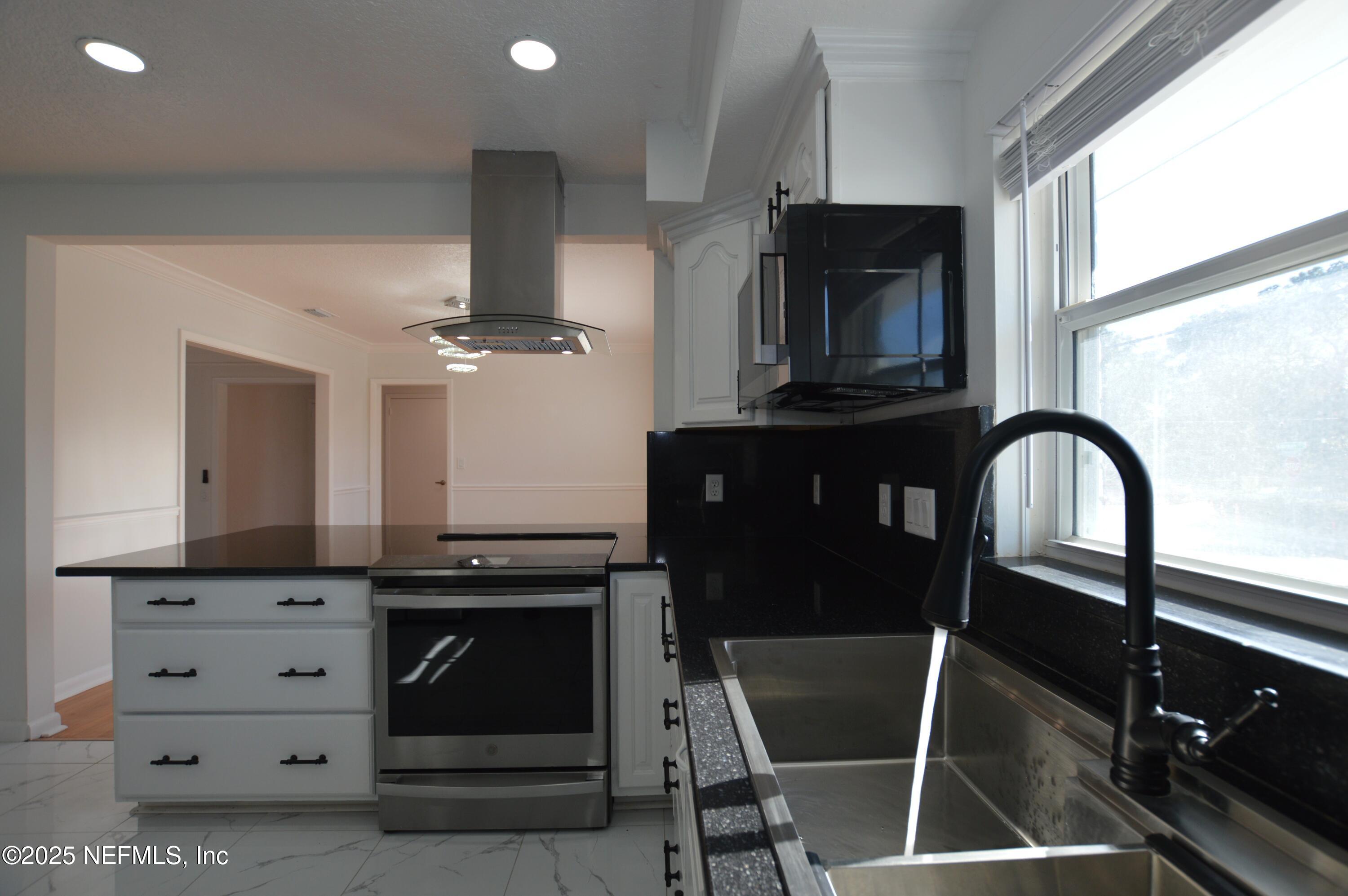 7941 Alderman Road Jacksonville, FL 32211 - Photo 11 of 40 a kitchen with granite countertop a stove and a refrigerator