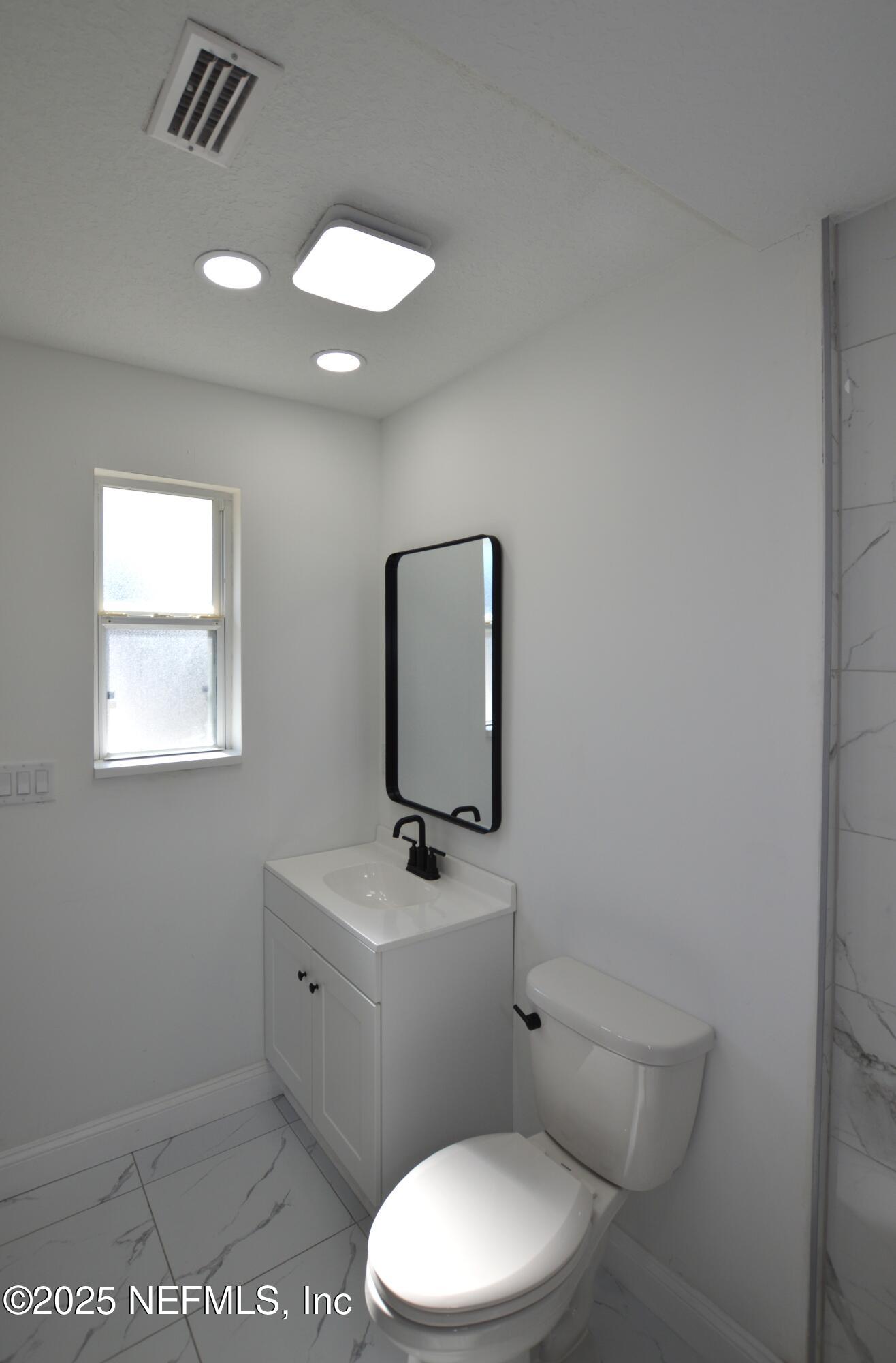 7941 Alderman Road Jacksonville, FL 32211 - Photo 19 of 40 a white toilet sitting next to a bathroom sink