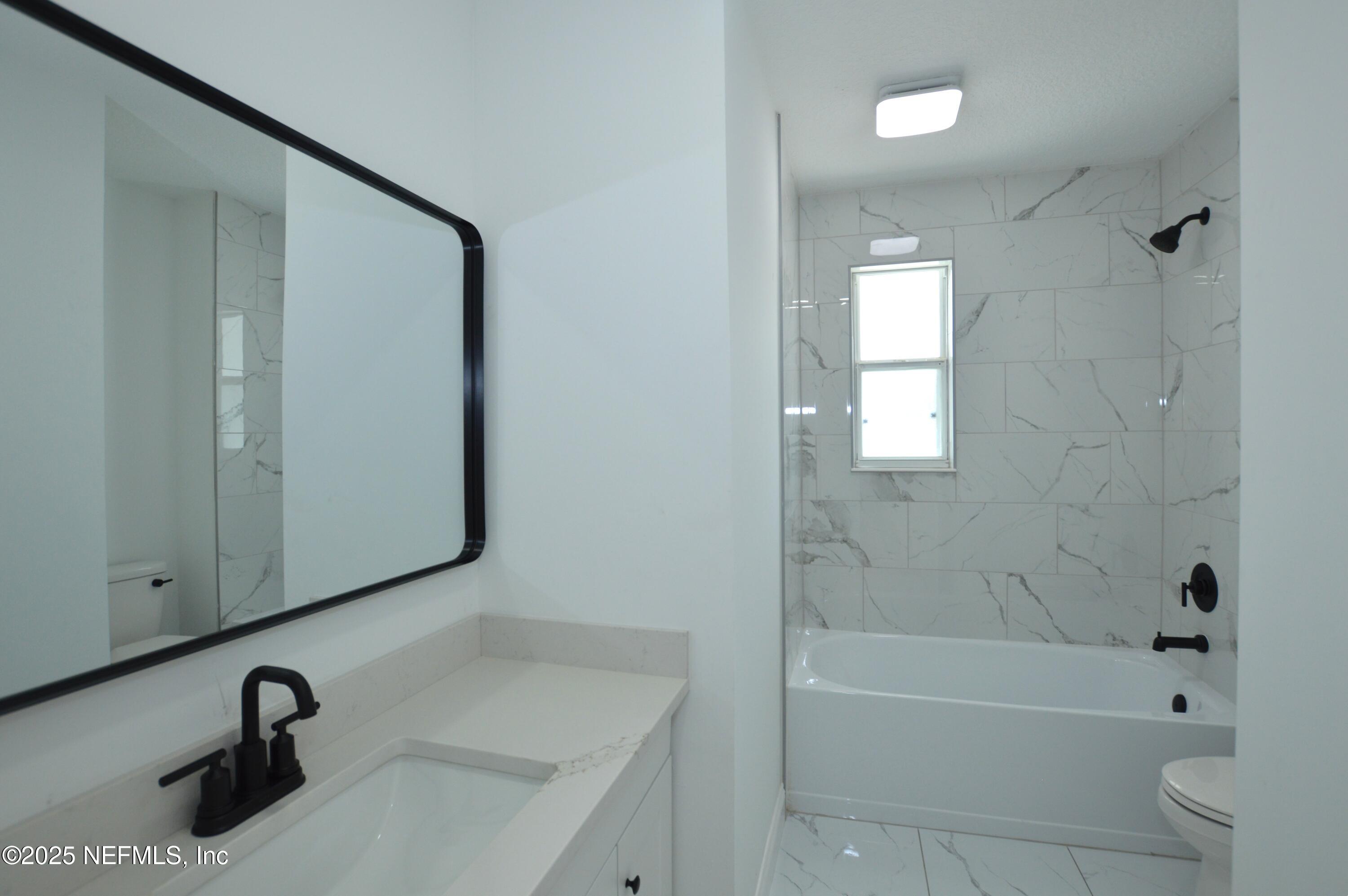 7941 Alderman Road Jacksonville, FL 32211 - Photo 24 of 40 a bathroom with a sink a toilet and shower