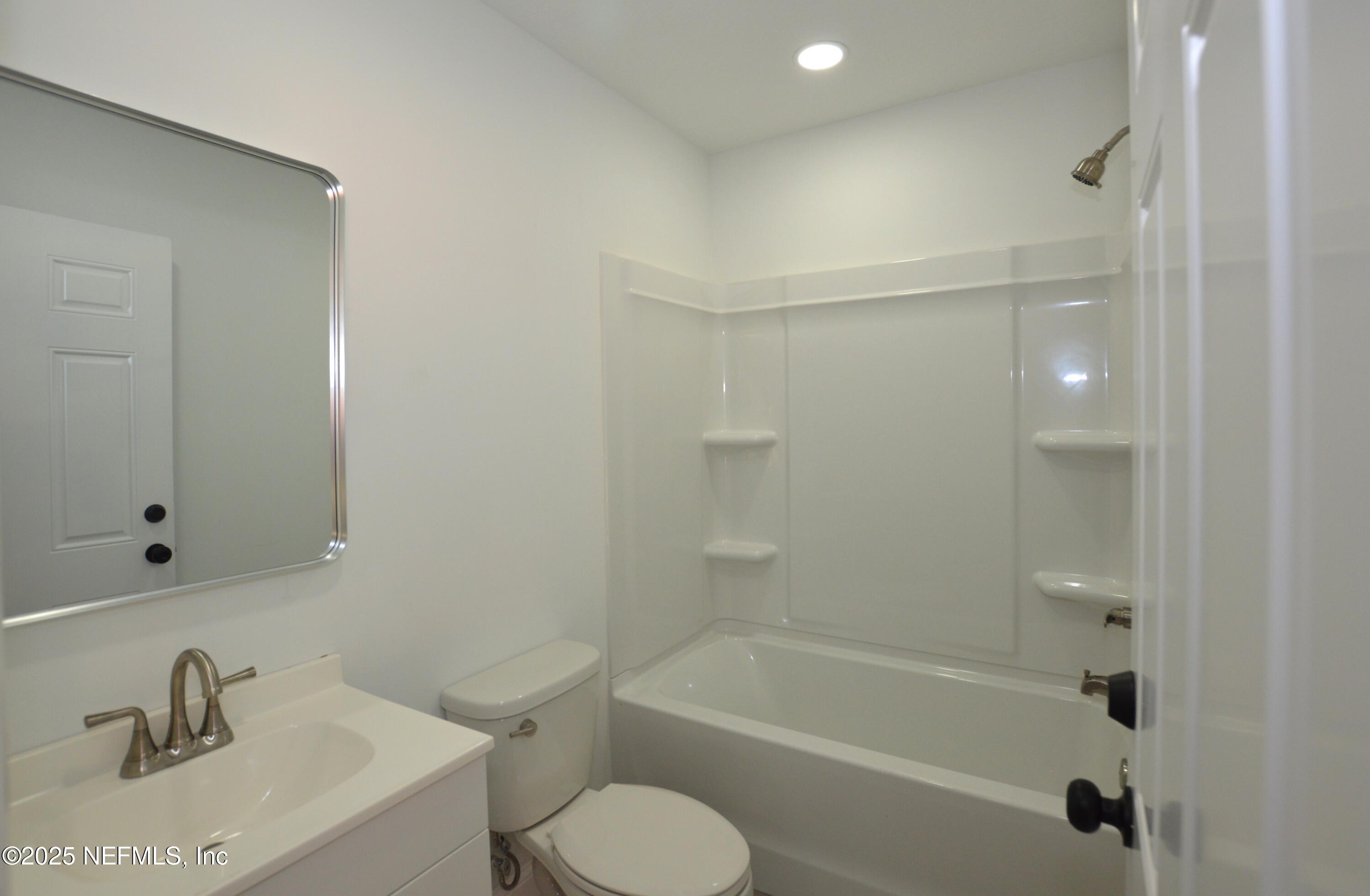 7941 Alderman Road Jacksonville, FL 32211 - Photo 32 of 40 a bathroom with a bathtub shower sink vanity and toilet