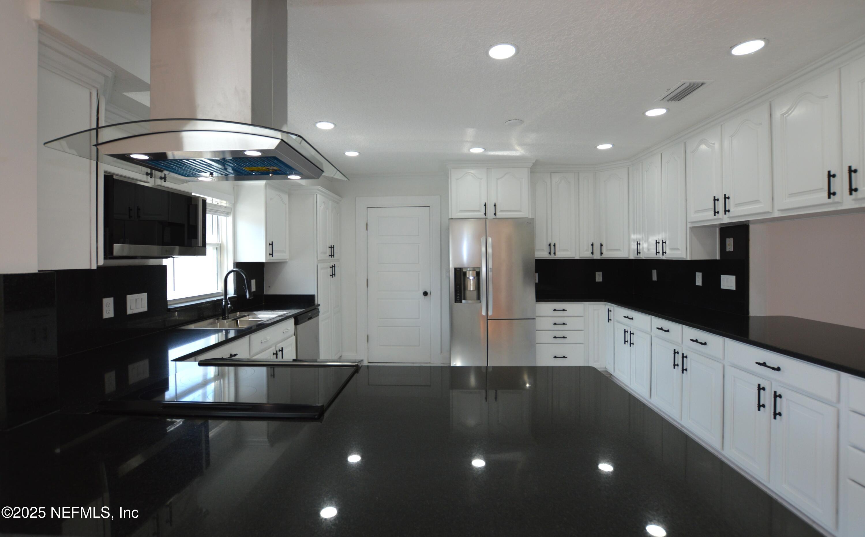 7941 Alderman Road Jacksonville, FL 32211 - Photo 8 of 40 a kitchen with stainless steel appliances kitchen island granite countertop a refrigerator and a stove top oven