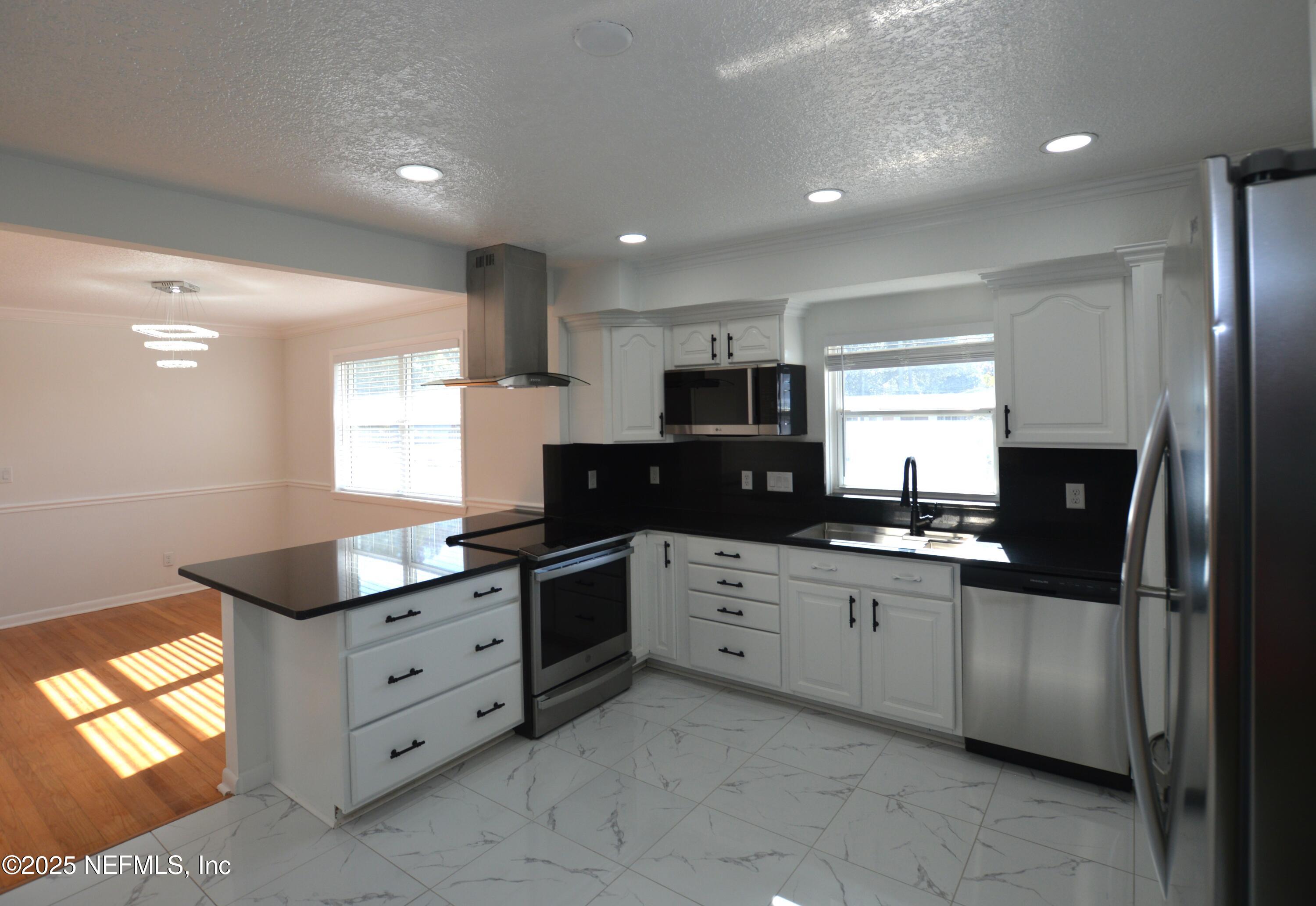 7941 Alderman Road Jacksonville, FL 32211 - Photo 9 of 40 a kitchen with granite countertop a sink and cabinets