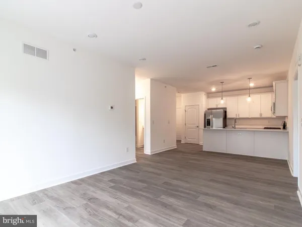 a view of a kitchen and an empty room