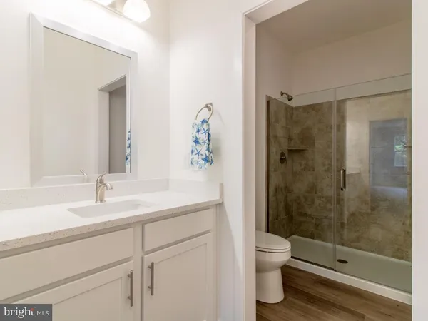 a bathroom with a granite countertop sink a toilet and shower