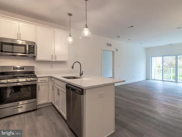 a kitchen with stainless steel appliances granite countertop a sink and a stove