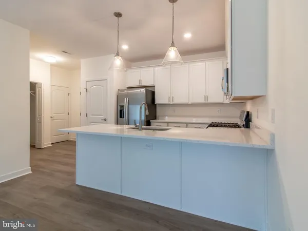 a kitchen with kitchen island a sink stainless steel appliances and cabinets