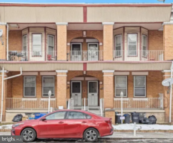 a front view of a residential apartment building with a yard