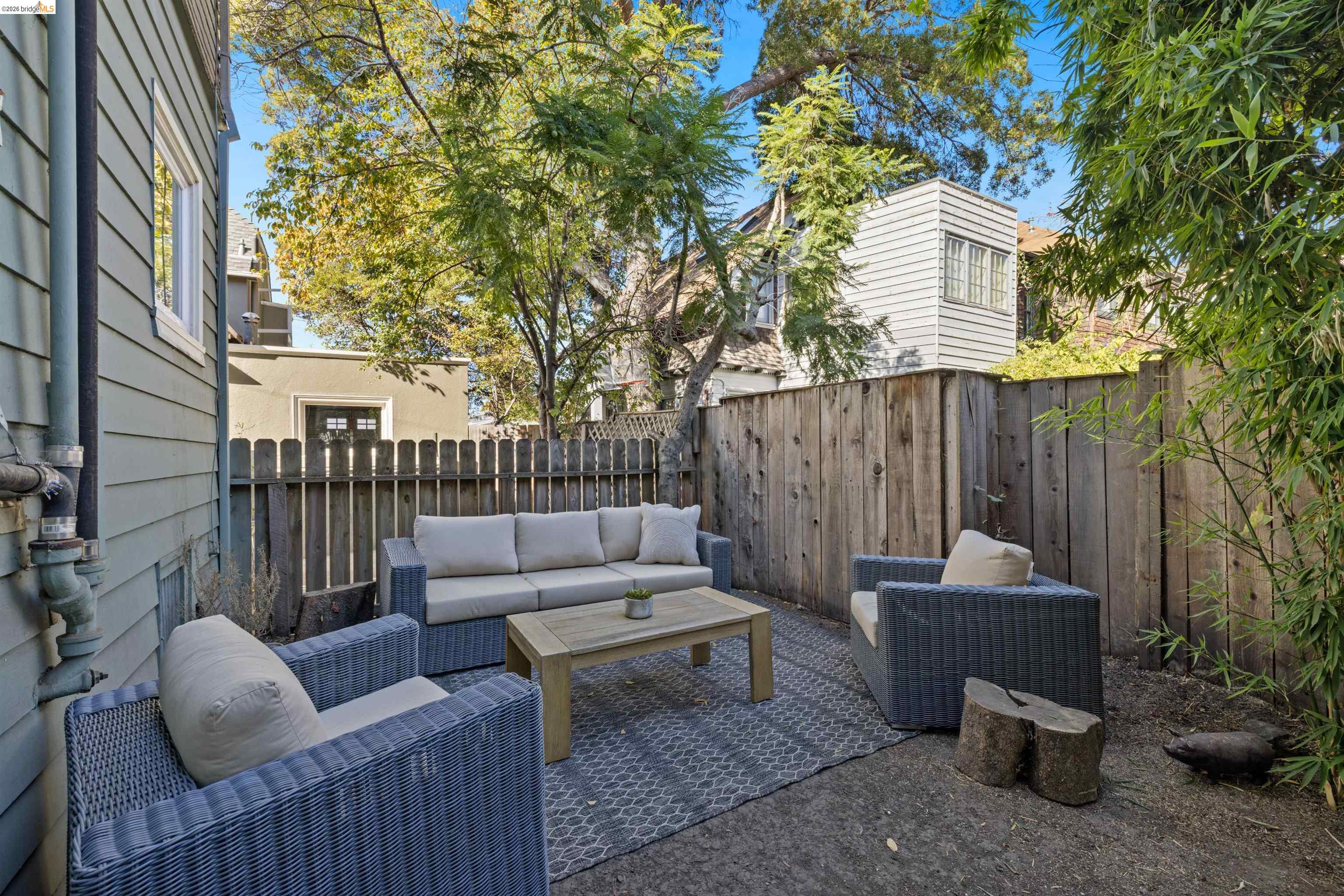 2935 Florence Street Berkeley, CA 94705 - Photo 11 of 12 a view of a patio with couches and a fire pit and wooden fence