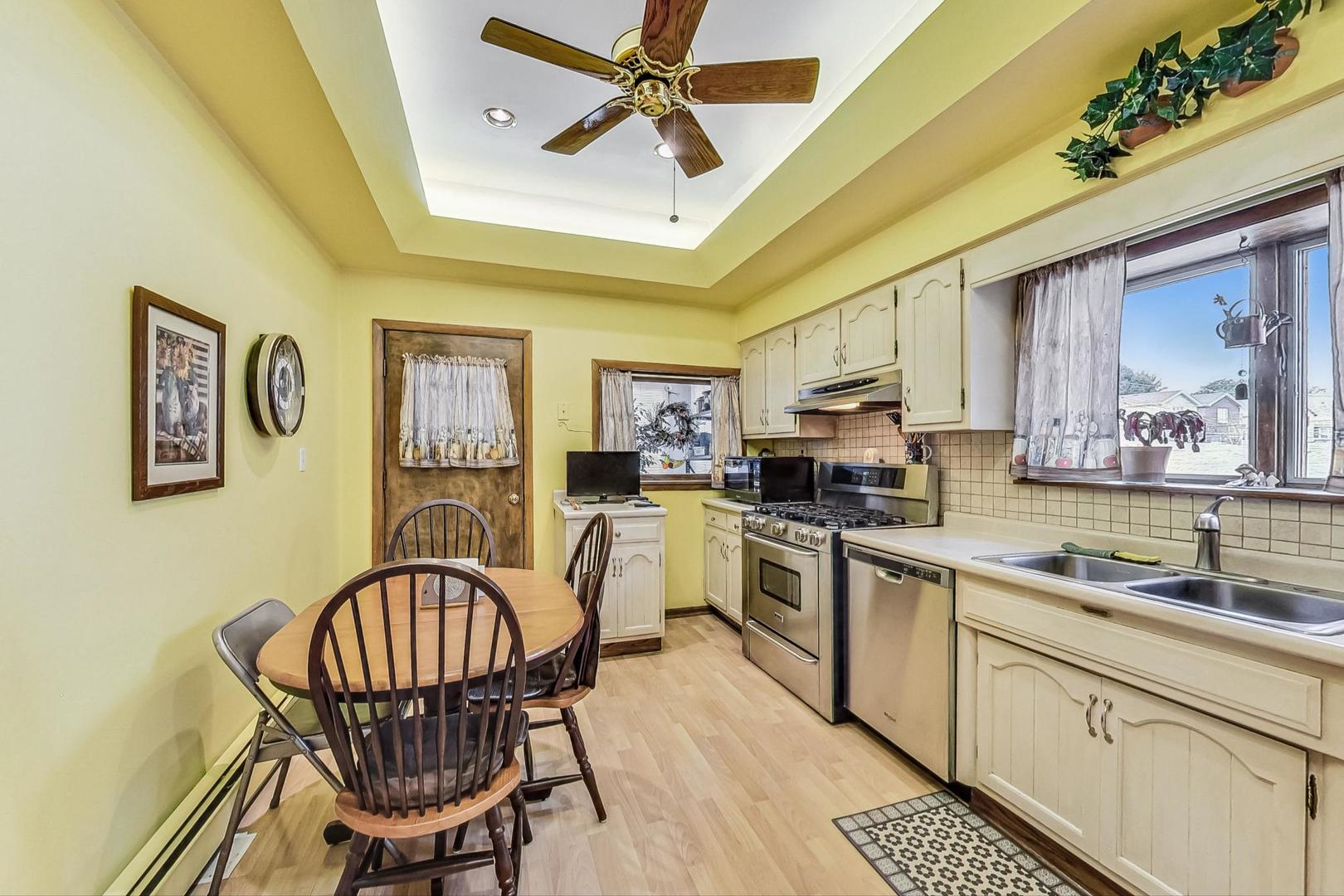2954 South Loomis Street Chicago, IL 60608 - Photo 15 of 80 a kitchen with stainless steel appliances a stove a sink dishwasher a dining table and chairs with wooden floor