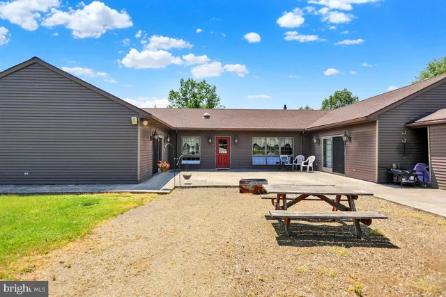 a view of a house with a big yard and sitting area