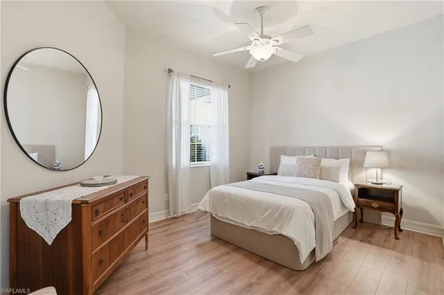 a bedroom with a bed a mirror and a window