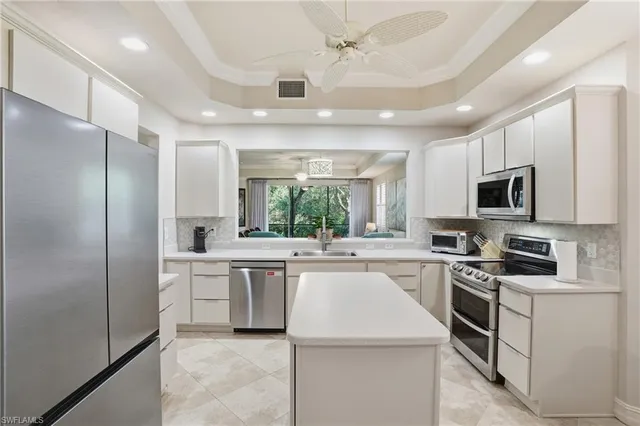 a kitchen with a sink stainless steel appliances and white cabinets