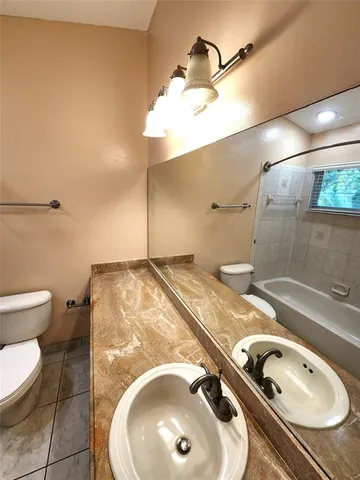 a bathroom with a sink a toilet and a mirror