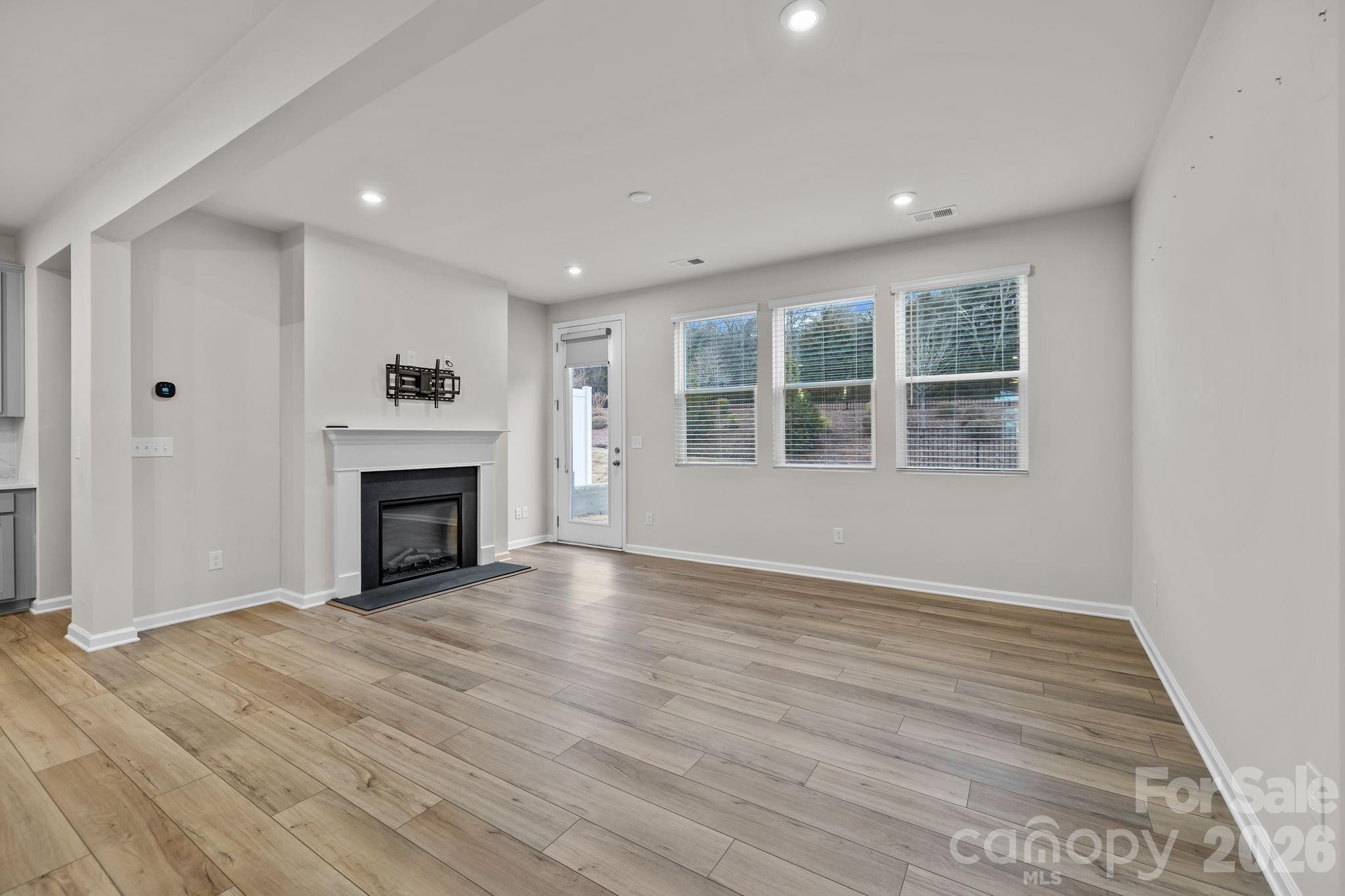 11246 Bartrams Way Charlotte, NC 28278 - Photo 13 of 31 a view of empty room with wooden floor and fireplace