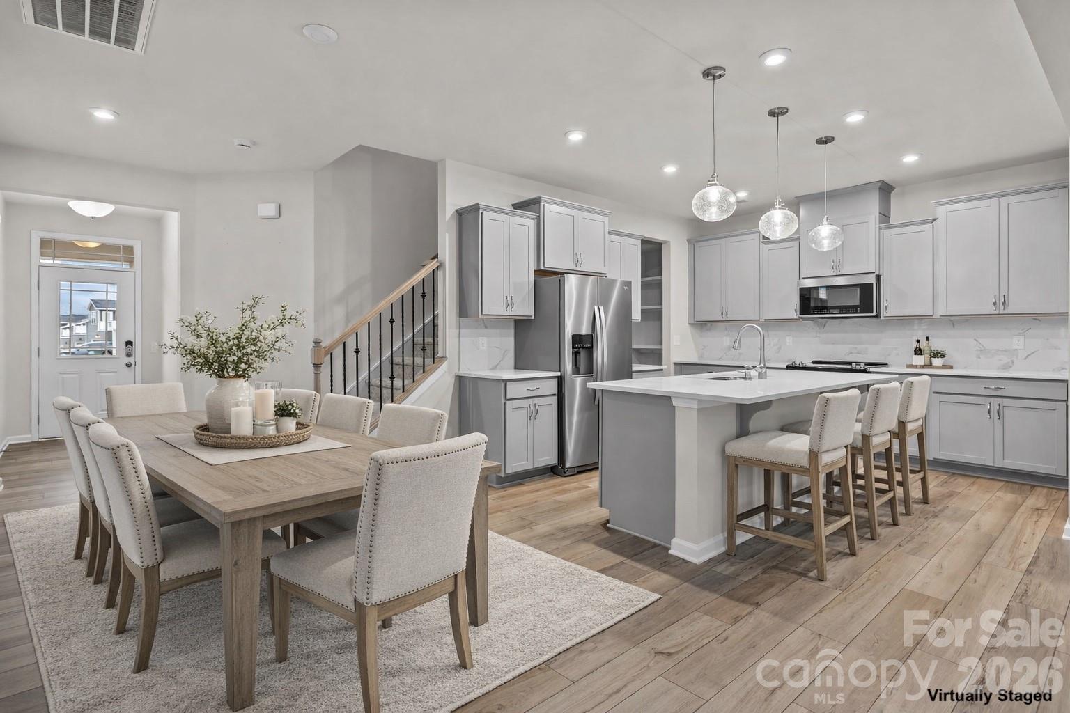 11246 Bartrams Way Charlotte, NC 28278 - Photo 5 of 31 a kitchen with stainless steel appliances kitchen island granite countertop a dining table chairs and a refrigerator