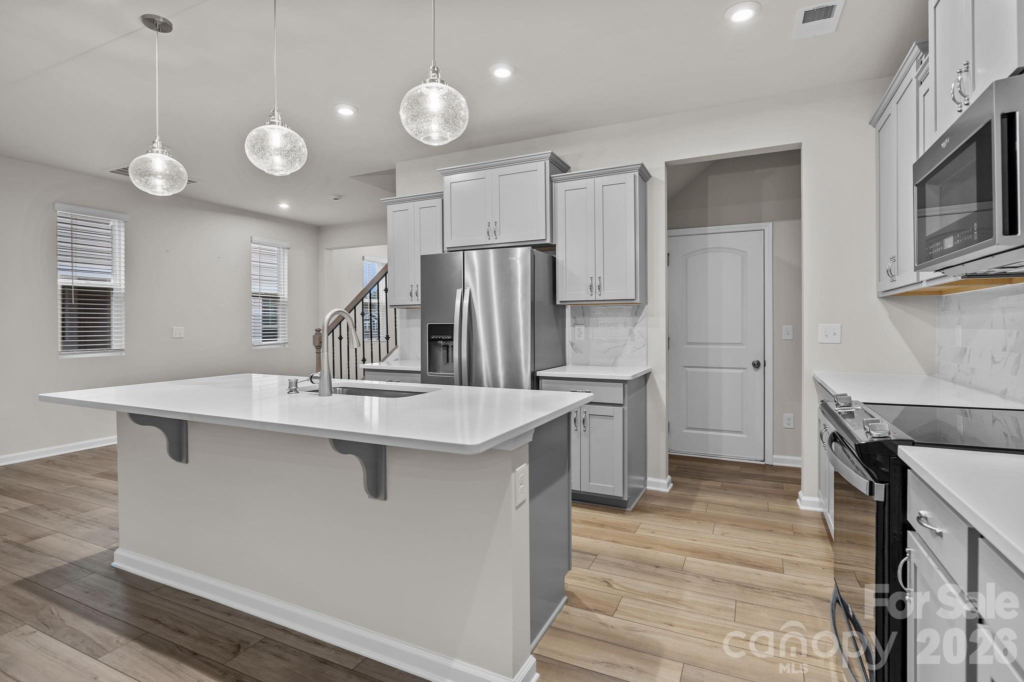 11246 Bartrams Way Charlotte, NC 28278 - Photo 7 of 31 a kitchen with stainless steel appliances a sink stove and refrigerator