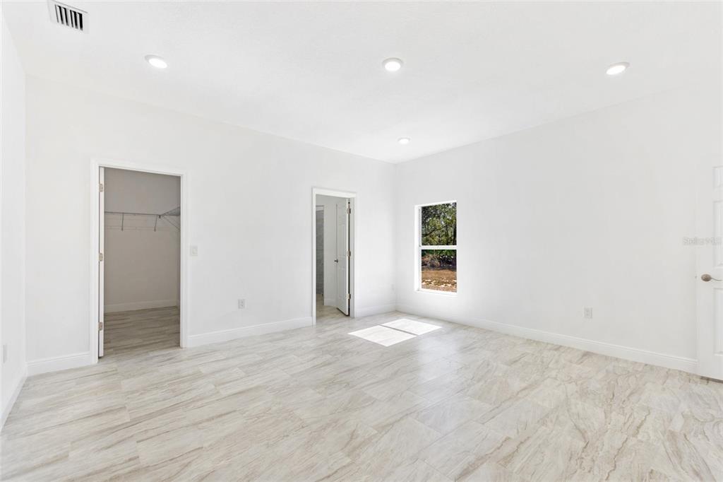 3121 Gardenia Drive Indian Lake Estates, FL 33855 - Photo 11 of 55 an empty room with wooden floor and windows