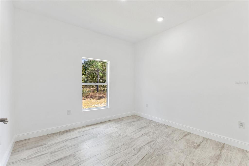 3121 Gardenia Drive Indian Lake Estates, FL 33855 - Photo 21 of 55 an empty room with wooden floor and window