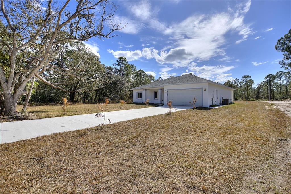 3121 Gardenia Drive Indian Lake Estates, FL 33855 - Photo 26 of 55 a front view of house with yard and trees around