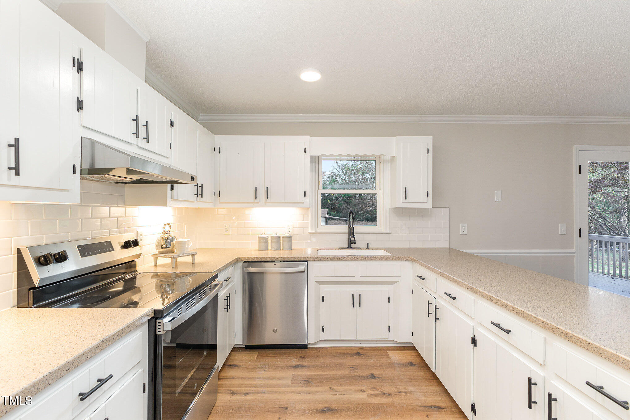 1046 Lipscomb Road Angier, NC 27501 - Photo 11 of 35 a kitchen with a sink dishwasher a stove and white cabinets with wooden floor