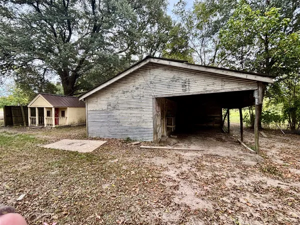 a view of a house with a yard and large tree