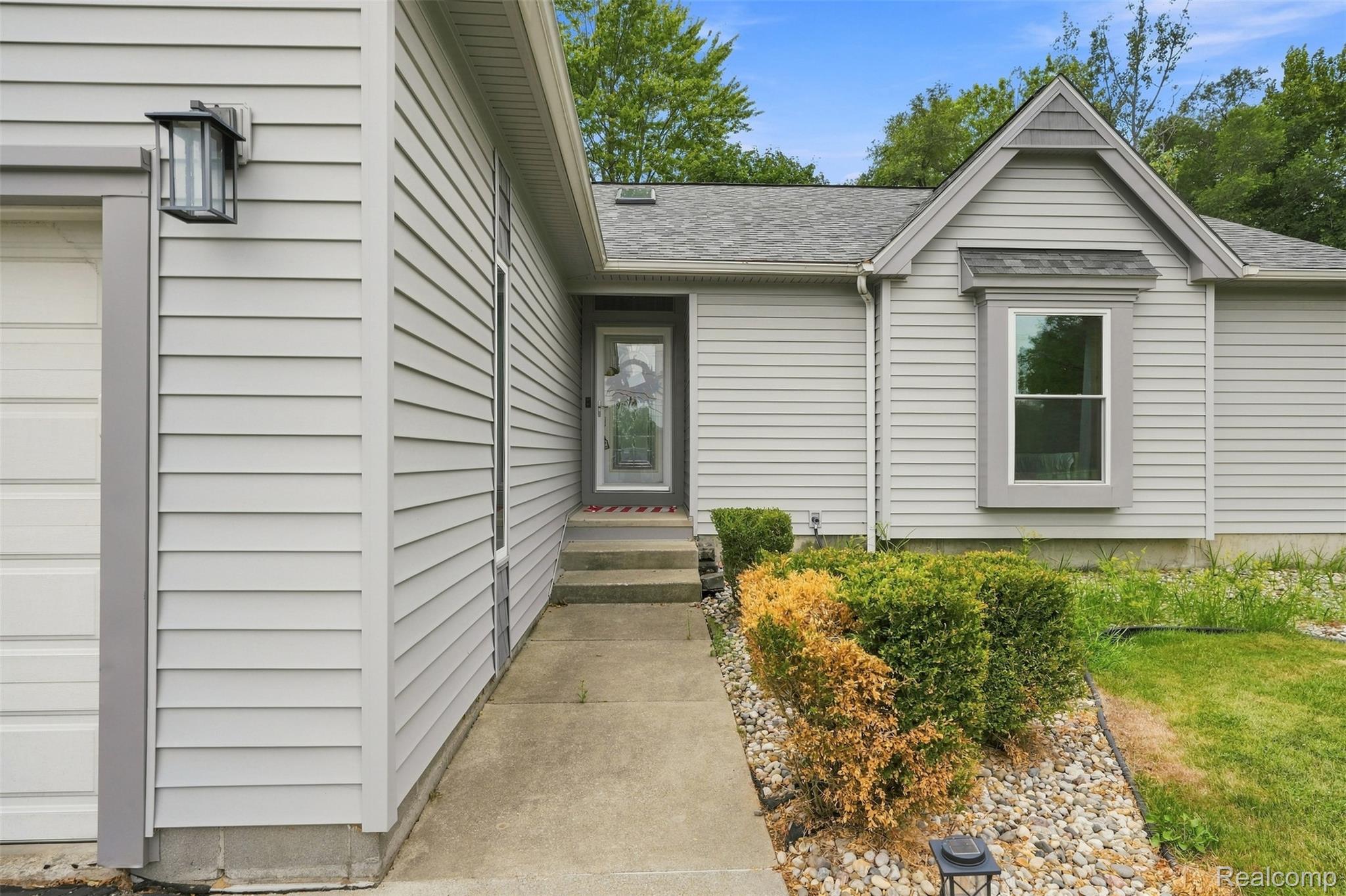 793 North Adams Road Rochester, MI 48309 - Photo 3 of 40 Light gray horizontal siding exterior with a dark gray trim and a covered entry