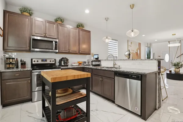 a cabinet with granite countertop lots of different kinds of food