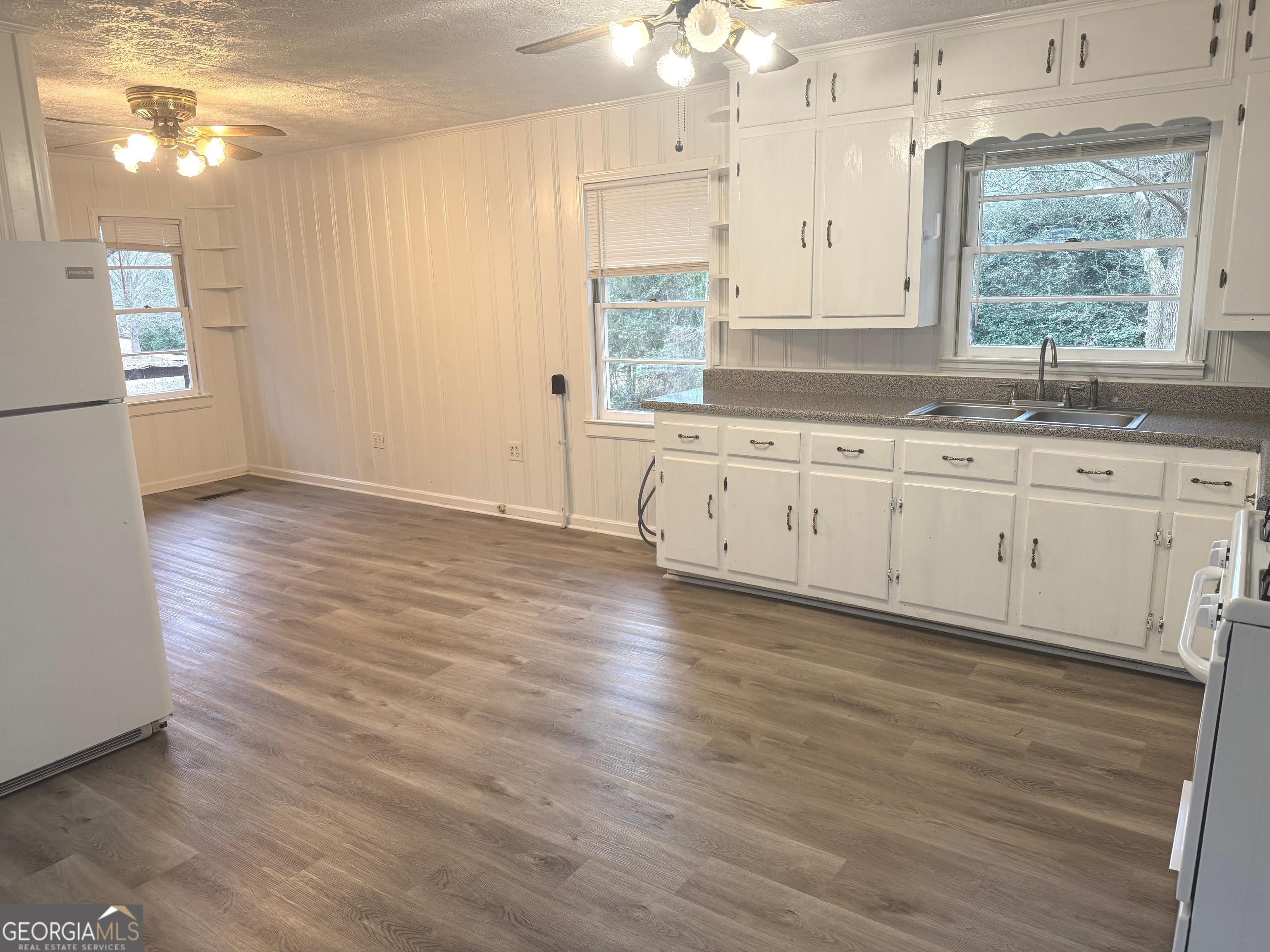 2308 Kelleytown Road McDonough, GA 30252 - Photo 6 of 13 a kitchen with granite countertop wooden floors white cabinets and sink