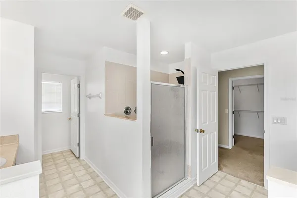 an empty room with a window and a ceiling fan