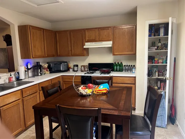a kitchen with granite countertop a sink appliances and cabinets