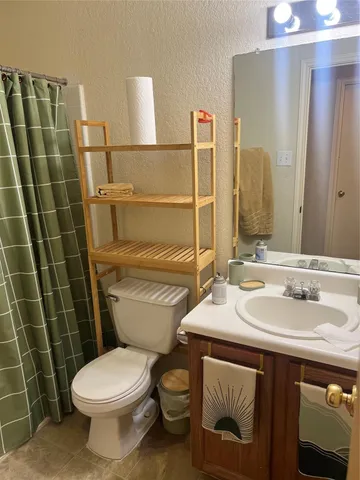 a view of a backyard with large trees and wooden fence