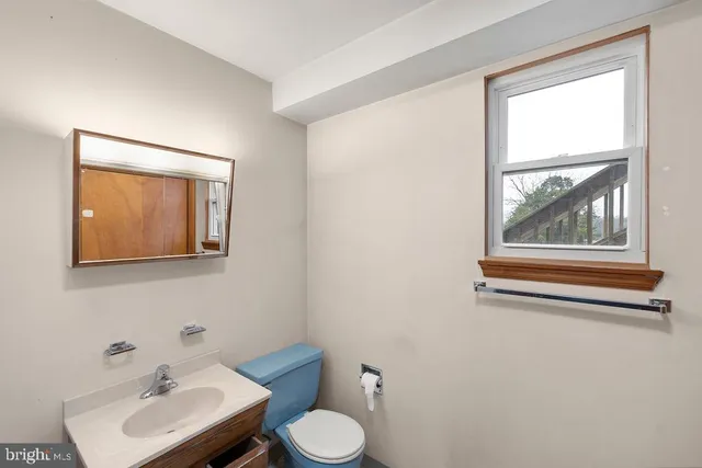 a bathroom with a toilet a sink and mirror