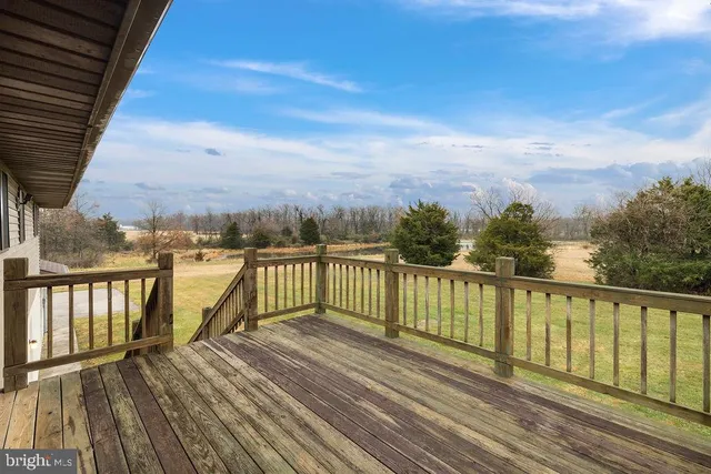 a view of balcony with wooden floor & fence